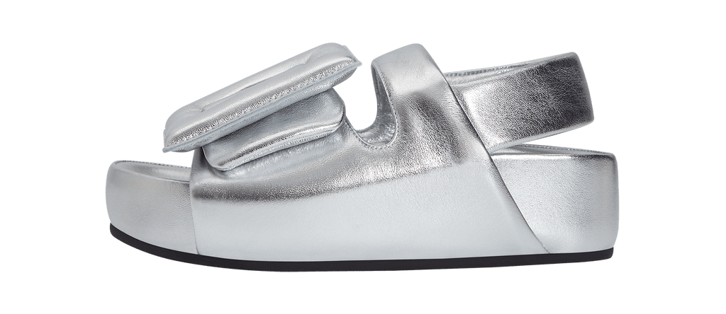 Metallic silver sandal with low ankle strap. Oversized puffy buckle and belt. Lambskin upper and insole.
