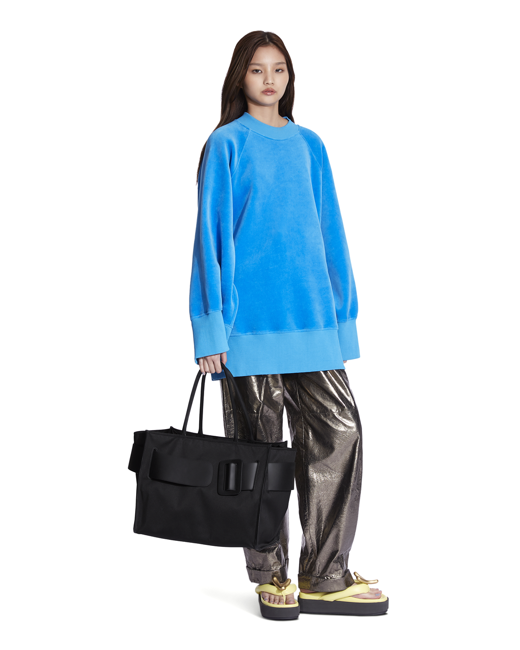 Black BOYY BOBBY soft luxury handbag made of econyl nylon with calfskin leather. Features a relaxed, modern silhouette with an oversized belt, buckle, and zipper closure on model