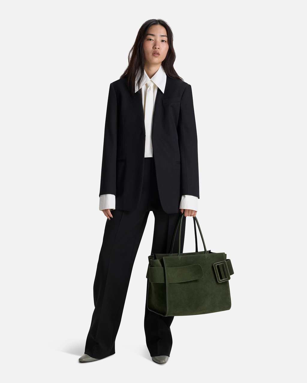 Sage Green BOYY BOBBY soft luxury handbag made of suede calfskin leather with fine-grain calfskin lining. Features a relaxed, modern silhouette, extended over the shoulder handles with an oversized belt, buckle, and zipper closure on model