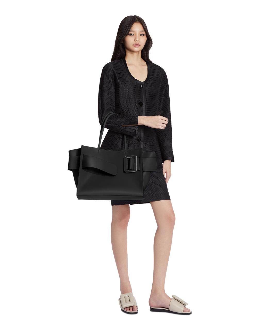 Black BOYY BOBBY soft luxury handbag made of fine-grain calfskin leather with alcantara suede lining. Features a relaxed, modern silhouette with an oversized belt, buckle, and zipper closure on model