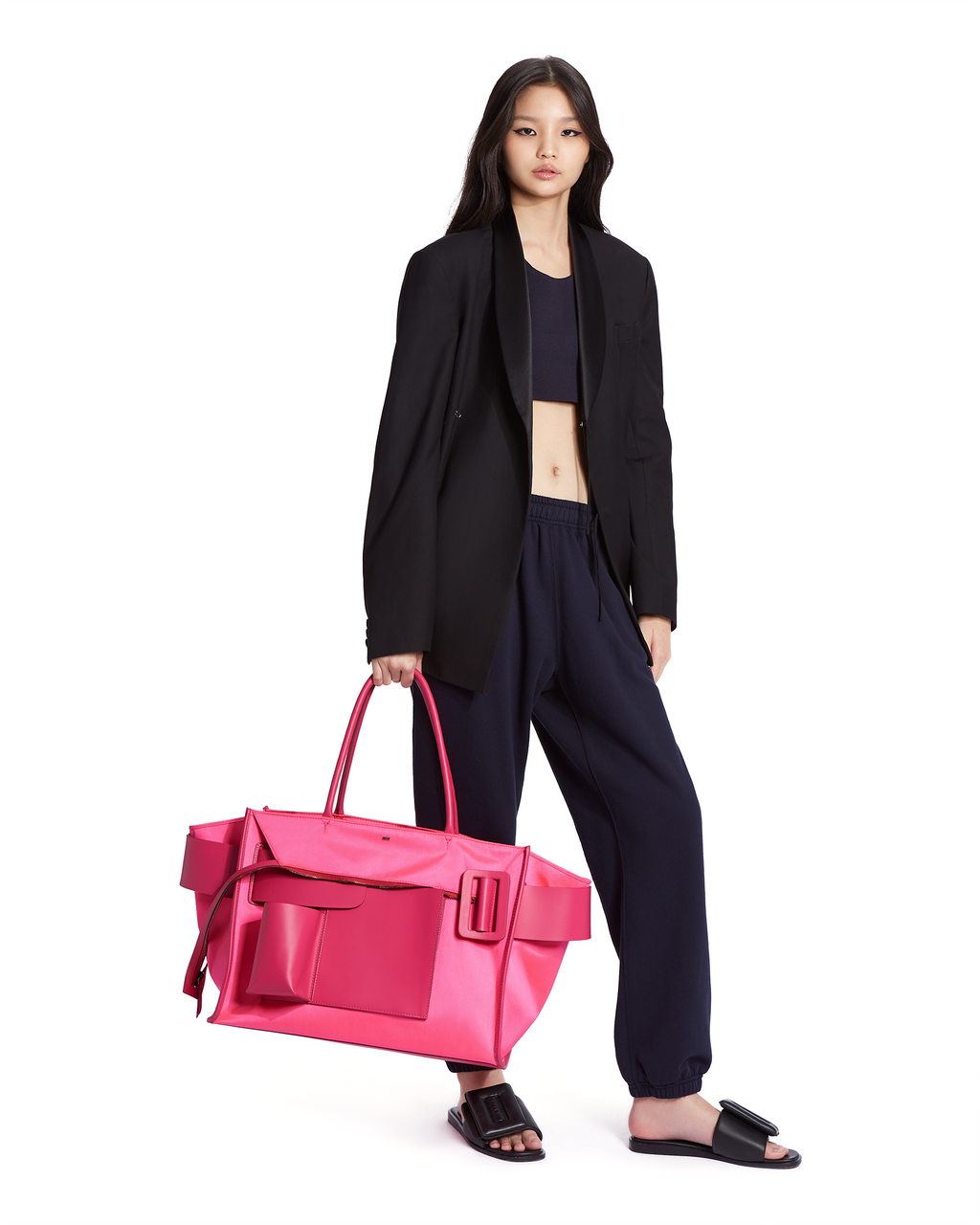 Neon pink BOYY BOBBY weekend inside-out soft luxury handbag made of econyl nylon with calfskin leather. Features a relaxed, modern silhouette with an oversized belt, buckle, and zipper closure on model